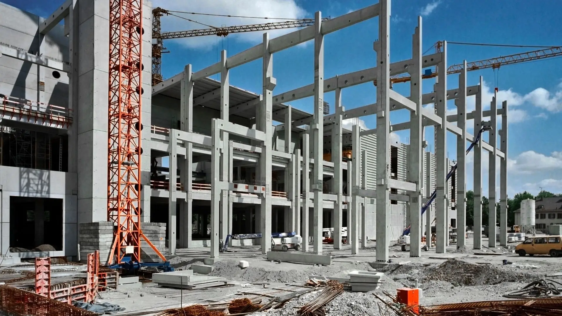 Obra de construcción con estructuras metálicas y maquinaria pesada en operación